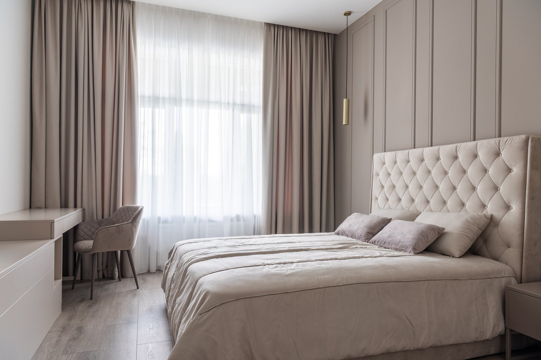 Apartment interior with bed near chair and curtains on windows